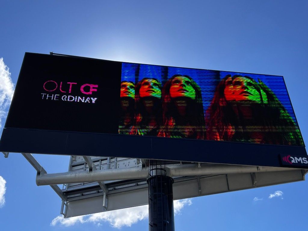 Outdoor digital billboard in daylight displaying a live campaign