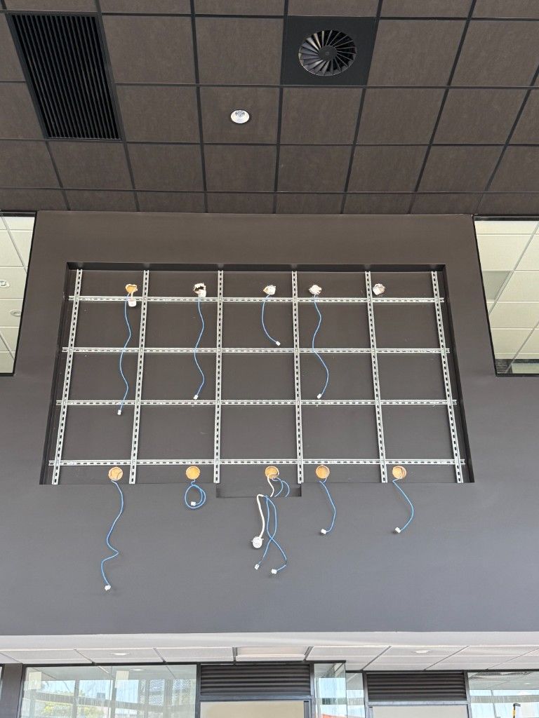 Indoor wall prepared for a video wall, with mounting rails and cable drops