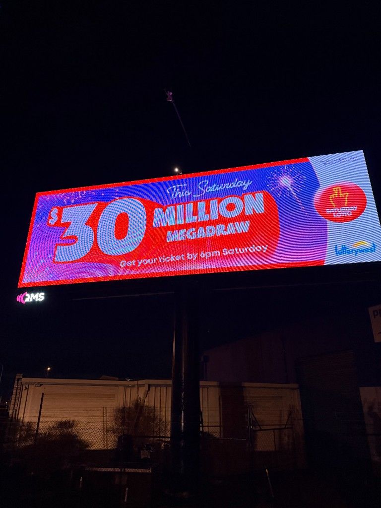 Outdoor digital billboard at night displaying a live campaign