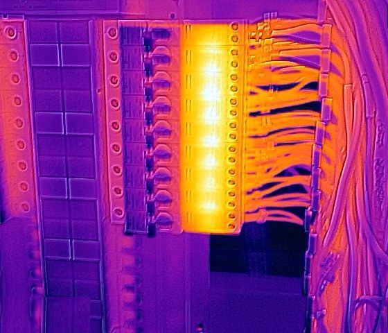 Thermal image of a distribution board with spot marks Sp1 on the warm terminal column and Sp2 on the adjacent column